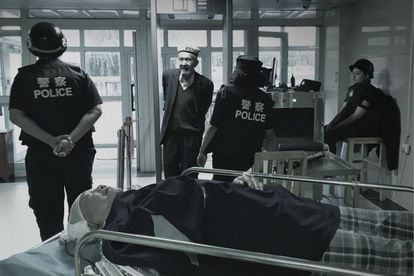 Um homem uigur passa por um controle de segurança para entrar em um hospital, em Xinjiang.