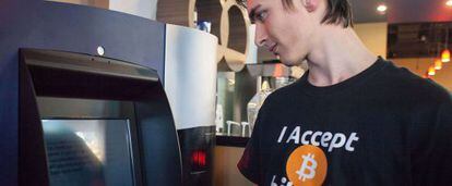 Um cliente observa o primeiro caixa de bitcoins.