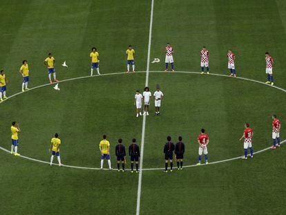Os jogadores se reúnem no centro do campo antes do início da partida.