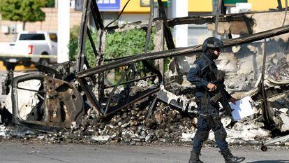 Um policial em frente a um veículo queimado nesta sexta-feira em Culiacán.