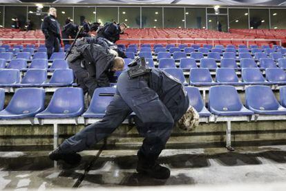 Policiais inspecionam as grades do estádio de Hanover.