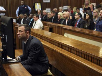 Oscar Pistorius sentado no banco dos réus minutos antes do começo do seu julgamento na Pretória.