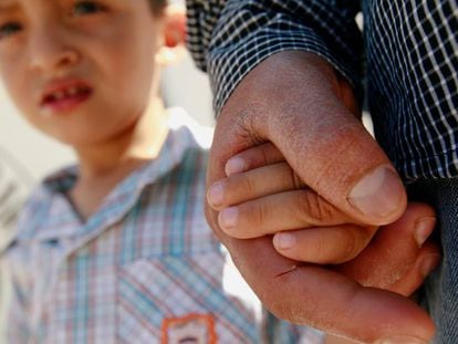 Imigrante salvadorenho Epigmenio Centeno segura a mão de seu filho, Steven. 