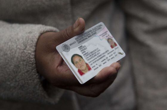 Uma mulher de 30 anos, registrada por Rosa Verduzco, mostra seu documento de identidade obtido hoje.