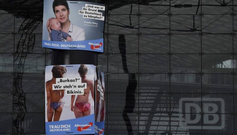 Cartazes de campanha do AfD onde se lê: "Qual é seu motivo para lutar pela Alemanha?" e "Burcas? Nós preferimos biquínis".