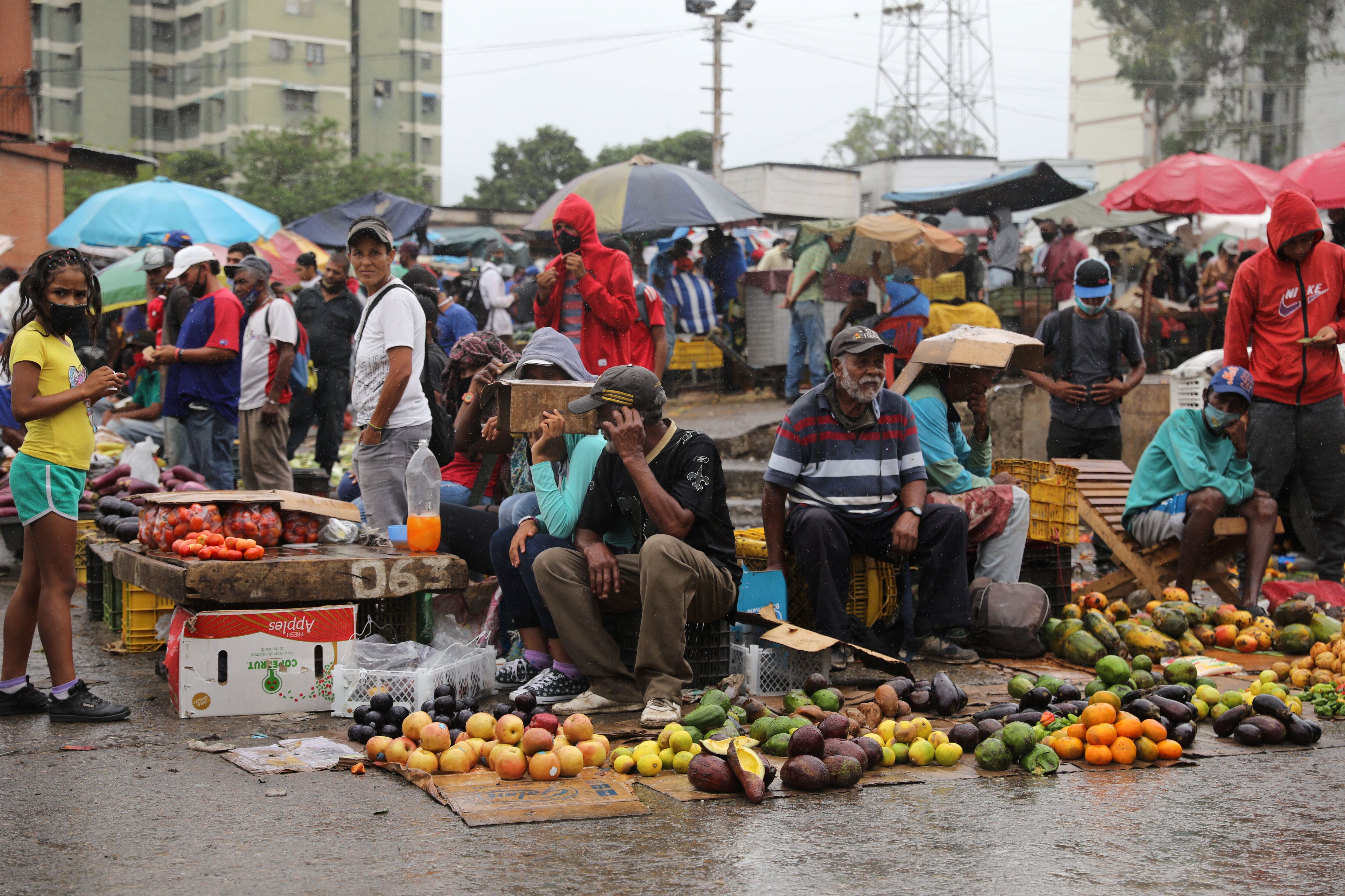 Vendedores trabalham no mercado de rua Coche, em Caracas, debaixo de chuva. 