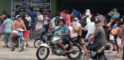 Um grupo de pessoas saqueia um supermercado nas periferias de Tucumán, no norte de Argentina.