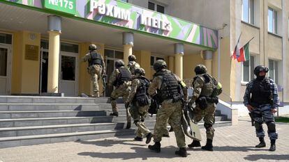 Policiais entram na escola após o tiroteio, nesta terça-feira, em Kazan.