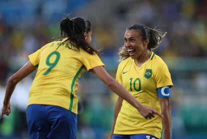 Marta e Andressa comemoram gol na estreia da seleção.