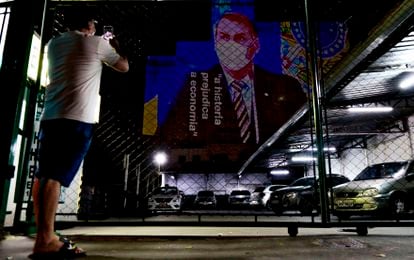 Um imagem do presidente Jair Bolsonaro com a frase "a histeria prejudica a economia" é projetada em prédio de São Paulo.
