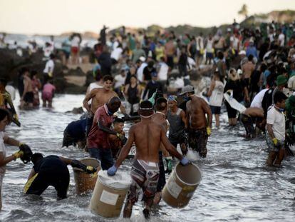 Na Pedra de Xaréu, Cabo de Santo Agostinho, Pernambuco, uma multidão de voluntários se organiza como pode para retirar o óleo da praia