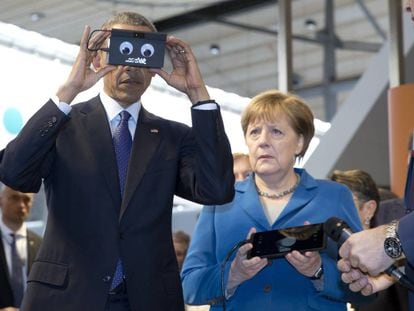 Barack Obama testa um gadget na presença de Angela Merkel durante sua visita a Hannover.