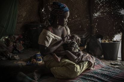 Mãe alimenta o filho com desnutrição num campo de refugiados.