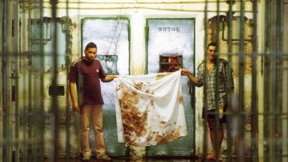 Detentos mostram panos sujos de sangue após o massacre, em outubro de 1992.