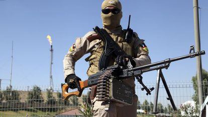 Integrante das forças de segurança curdas vigia refinaria perto de Mossul (Iraque).