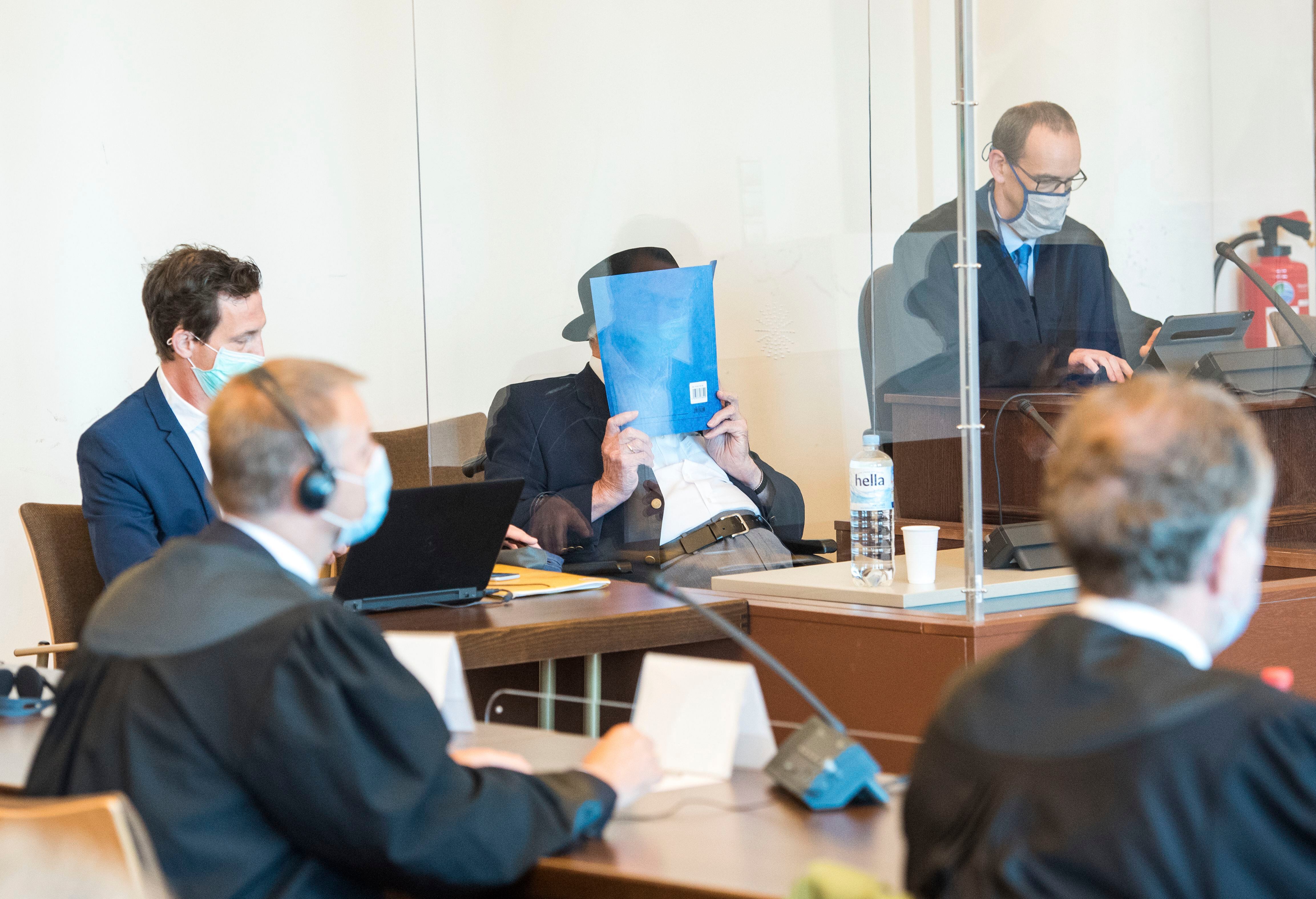 Bruno Dey, de 93 anos, esconde o rosto com uma pasta durante seu julgamento em Hamburgo. DANIEL BOCKWOLDT 