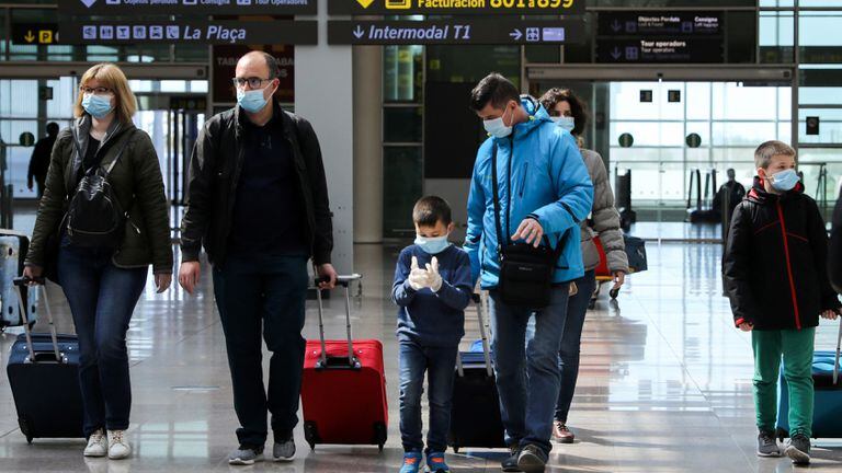 Families wear protective face masks as they walk with their luggage at Tarradellas Barcelona-El Prat Airport, after further cases of coronavirus were confirmed in Barcelona, Spain March 11, 2020. REUTERS/Nacho Doce