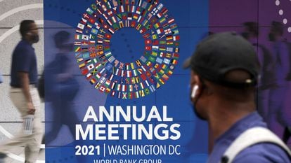 Um homem passa por um cartaz das reuniões anuais do Grupo do Banco Mundial e do Fundo Monetário Internacional, nesta segunda-feira, em Washington.