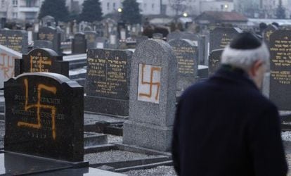 O líder de uma comunidade judaica examina tumbas pintadas com suásticas em um cemitério perto de Estrasburgo, em 2010.