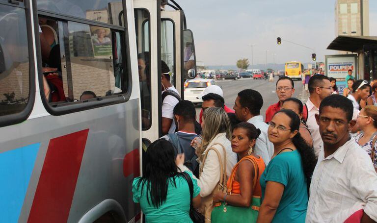 Pessoas em ponto de ônibus de Brasília.