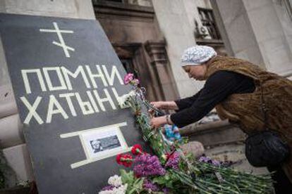 Uma mulher deposita flores em frente a prédio onde mais de 40 morreram em Odessa, na Ucrânia.