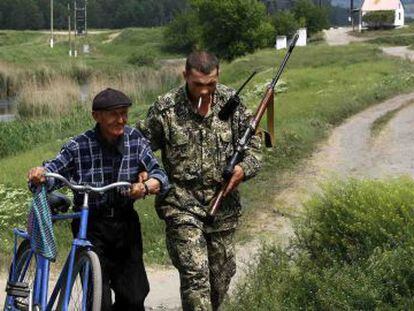Um rebelde pró-russo ajuda um homem em Slaviansk.