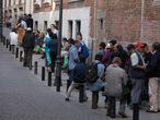 Um grupo de pessoas faz fila para entrar em um refeitório social em Madri