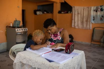 Uma mãe ensina a tarefa escolar ao filho em casa, no Rio de Janeiro.