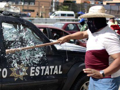 Homem quebra o vidro de um carro policial em Chilpancingo.