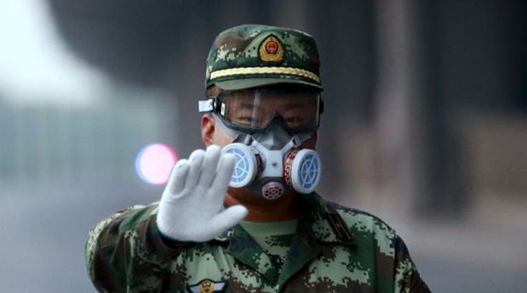 Um policial para a um fotógrafo que pretendia aceder à zona que foi evacuada em Tianjin, nesta segunda-feira.