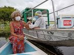 (FILES) In this file photo taken on February 09, 2021 Olga D'arc Pimentel, 72, is vaccinated by a health worker with a dose of Oxford-AstraZeneca COVID-19 vaccine in the Nossa Senhora Livramento community on the banks of the Rio Negro near Manaus, Amazonas state, Brazil. (Photo by MICHAEL DANTAS / AFP)