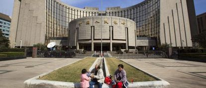 Uma família em frente ao Banco Popular da China, em Pequim.