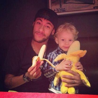 Neymar, com seu filho, mostrando uma banana.