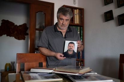 Juan Antonio Dutoit, pai de Juan Carlos, um jovem que morreu de coronavírus em Sevilha, mostra uma fotografia do filho. 
