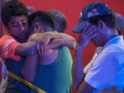 Várias pessoas se abraçam após um tiroteio que causou 23 mortos em um bar em Veracruz (México) em agosto.