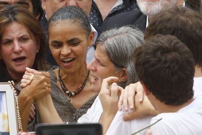 Marina segura na m&atilde;o de Renata na missa p&uacute;blica de Eduardo Campos.