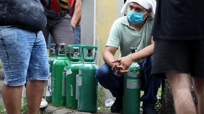 Parentes de pacientes hospitalizados ou recebendo assistência médica em casa, a maioria com Covid-19, fazem fila para comprar oxigênio e encher cilindros em uma empresa privada em Manaus
