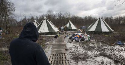 Um migrante caminha até um dos alojamentos do campo de Grande-Synthe (França).