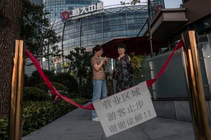 Várias pessoas diante do Centro Evergrande em Xangai, nesta terça-feira.