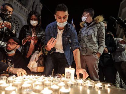 Pessoas acendem velas do lado de fora da Basílica de Notre-Dame de l'Assomption, em Nice, em homenagem às três vítimas do atentado.