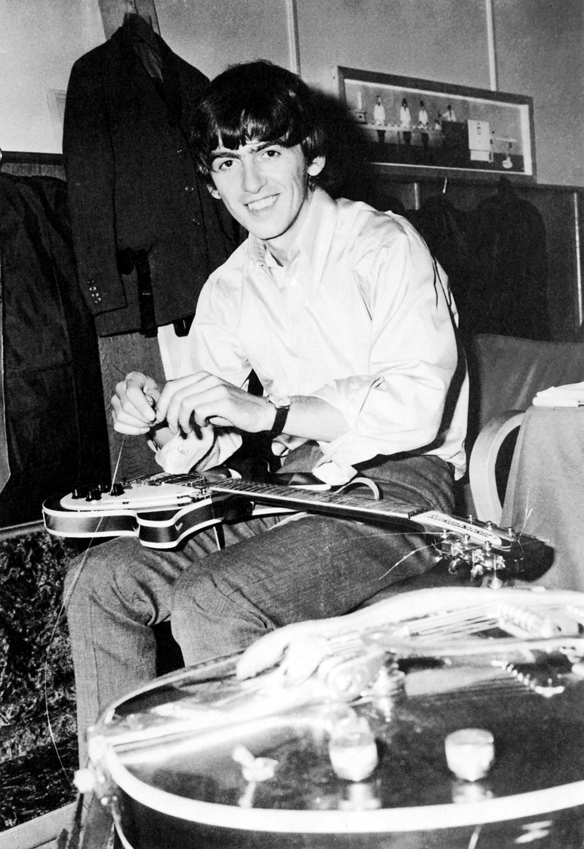 O músico troca as cordas da sua guitarra em 1965, na época dos Beatles.