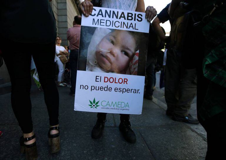 Mulher mostra cartaz a favor da legalização da maconha para fins medicinais, nesta quarta-feira.