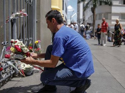 Um homem deixa flores para as vítimas da Catedral de Campinas.