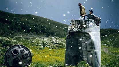 Aldeões recolhendo restos de um foguete espacial rodeados de mariposas, na República de Altai, Rússia, em 2000