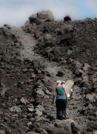 Dois turistas escalam o vulcão Cerro Negro.