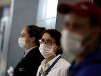 Airport employees, wearing masks as a precautionary measure to avoid contracting coronavirus, are seen at Guarulhos International Airport in Guarulhos, Sao Paulo state, Brazil, February 6, 2020. REUTERS/Amanda Perobelli