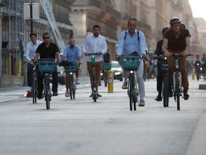 Dezenas de pessoas pedalam pela ciclovia da rue de Rivoli, uma das ruas mais centrais de Paris