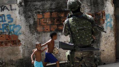 Crianças observam patrulhas das forças armadas no Rio de Janeiro.