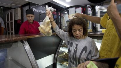 Clientes compram pão subsidiado em uma confeitaria de Caracas