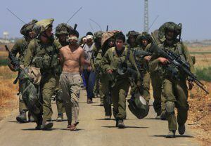 Soldados israelenses escoltam um grupo de palestinos detidos próximo a Kissufim.